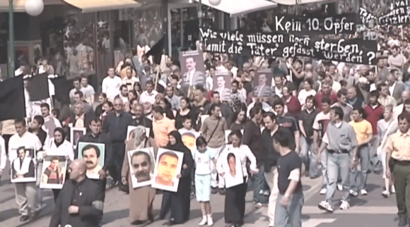 Kassel, 6 Mayıs 2006. ''10. Kurban Olmasın!'' talebiyle 2000'den fazla insan gösteri yapmıştı. c) Screenshot der ARD-Dokumentation »Acht Türken, ein Grieche, eine Polizistin«